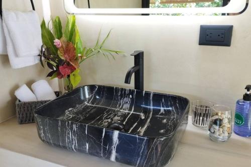 ein schwarzes Waschbecken im Bad mit einer Theke in der Unterkunft Casa Sol y Luna, Santa Teresa in Playa Santa Teresa