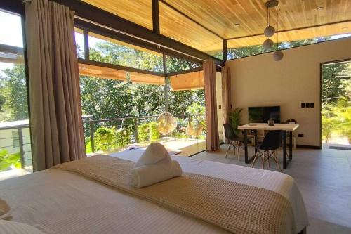 ein Schlafzimmer mit einem großen Bett und einem großen Fenster in der Unterkunft Casa Sol y Luna, Santa Teresa in Playa Santa Teresa