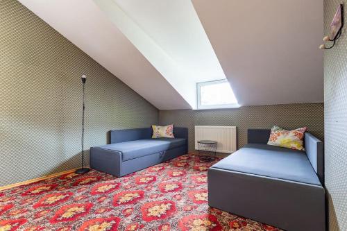 Cette chambre mansardée comprend 2 lits et un tapis. dans l'établissement New House, Private Garden & Parking City Center, à Klaipėda