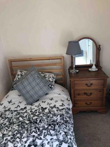 a bedroom with a bed with a pillow and a mirror at Haworth Prime Location 3 Bedroom Duplex Apartment in Haworth