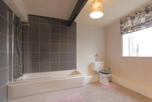 a bathroom with a bath tub and a toilet at Haworth Prime Location 3 Bedroom Duplex Apartment in Haworth