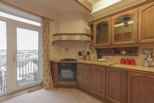 una cocina con armarios de madera y una gran ventana en Haworth Prime Location 3 Bedroom Duplex Apartment, en Haworth