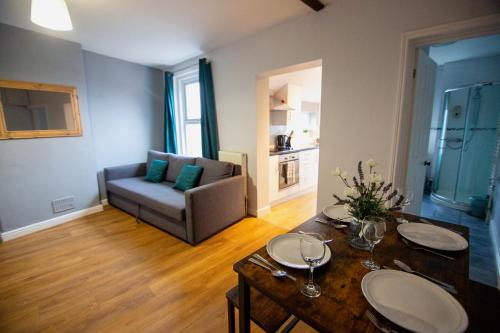 a living room with a couch and a table with wine glasses at George Street Apartment in Salisbury