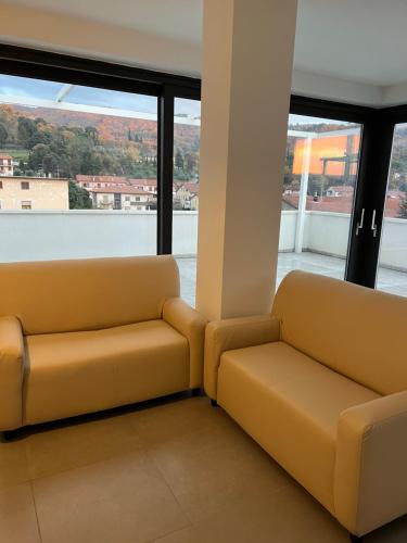 two yellow couches in a room with windows at Donati Business Rooms in Subbiano