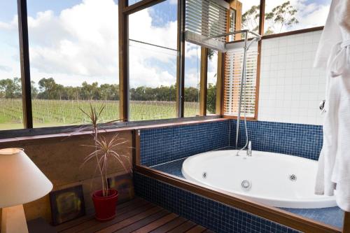 a bathroom with a tub and a large window at Bettenays Margaret River in Metricup