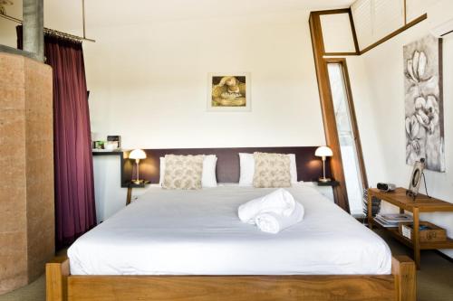 a bedroom with a large bed with white sheets at Bettenays Margaret River in Metricup