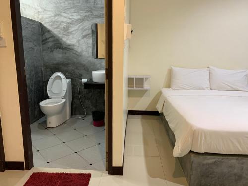 a bathroom with a bed and a toilet in a room at Ban Bunsawaeng Resort in Chaiyaphum