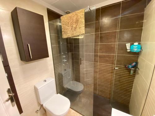 a bathroom with a toilet and a glass shower at Espectacular apartament a Palamós centre! Amb WIFI in Palamós