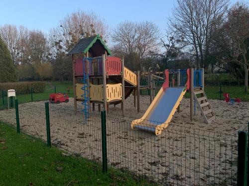 um parque infantil com um escorrega e uma estrutura de jogos em Zénithouse em Éterville