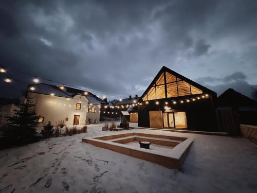 a large house with a snow covered yard at night at BarnHaus in Jibert