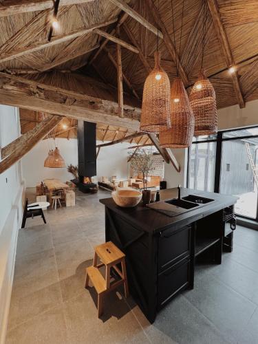 a kitchen with a black island and pendant lights at BarnHaus in Jibert