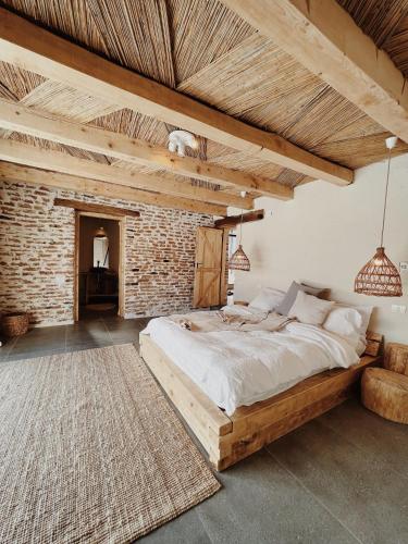 a bedroom with a large bed and a brick wall at BarnHaus in Jibert