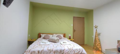 a bedroom with a large bed and a christmas tree at KovacInalux Apartmani in Pale
