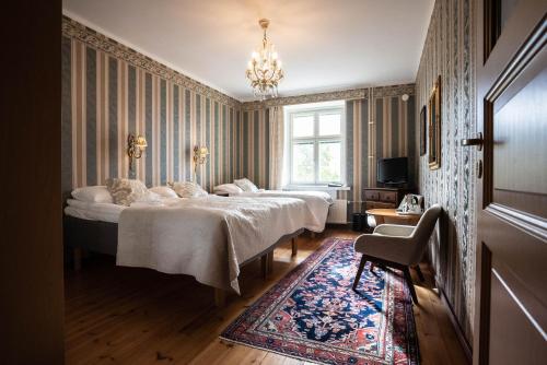 a bedroom with two beds and a chandelier at Hotel Hospitz in Savonlinna