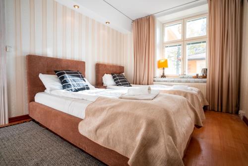 two large beds in a bedroom with a window at Hotel Hospitz in Savonlinna