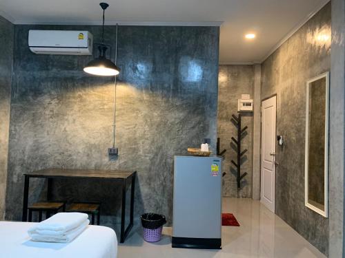 um quarto com um frigorífico e uma mesa em Ban Bunsawaeng Resort em Chaiyaphum