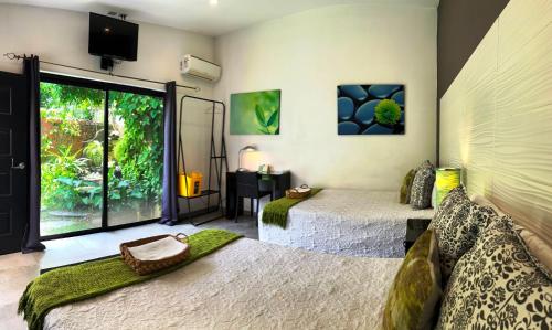 a bedroom with two beds and a large window at Hotel Boutique Valverde Santa Elena in San Salvador