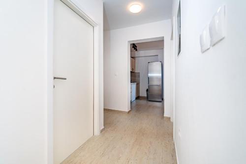 a hallway with white walls and a hard wood floor at Merita Apartments with Pool in Sveti Filip i Jakov