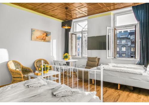 维也纳Welcoming 2BR Apt. Near Danube & Millenium Tower的有两张床、一张桌子和几把椅子的房间