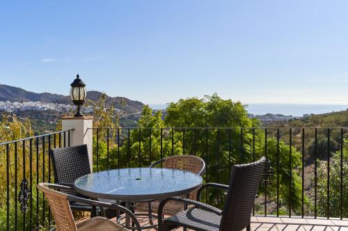 a patio with a table and chairs on a balcony at Group Villa 14 Pool wifi Air in Frigiliana