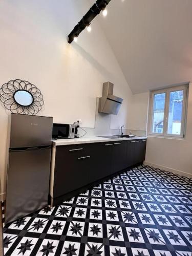 Il comprend une cuisine dotée de carrelage noir et blanc. dans l'établissement LOFT DU BRAS DOR, à Boulogne-sur-Mer