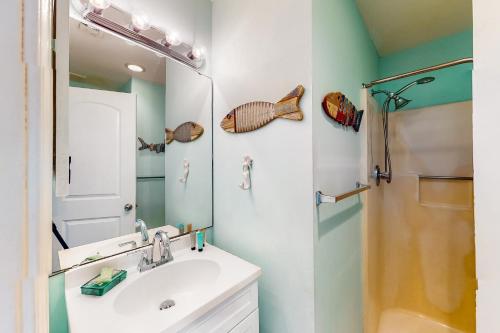 y baño con lavabo, ducha y espejo. en Poolside Villas #206, en Destin