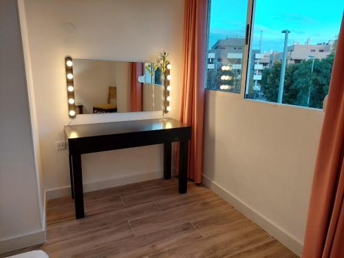 a bathroom with a desk and a mirror and a window at Hostal GARDEN ROUS in Paiporta