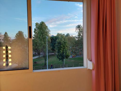 a window with a view of a park at Hostal GARDEN ROUS in Paiporta