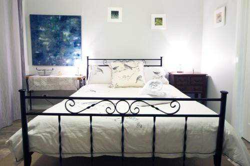 a bedroom with a black bed with white sheets at Bettenays Margaret River in Metricup