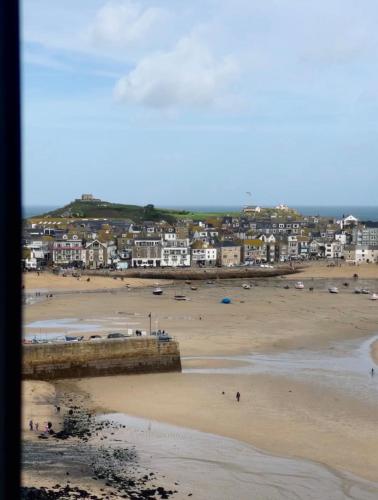a view of a beach with a town in the background at Harbour View House in St Ives