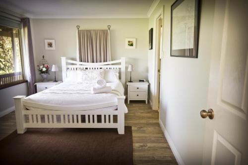 a bedroom with a white bed and a door at Bettenays Margaret River in Metricup