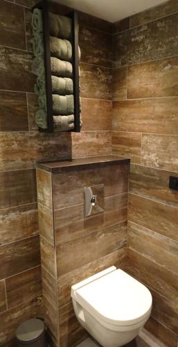 a bathroom with a white toilet and wooden walls at Molenzicht in Sint Maarten