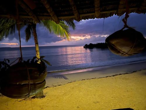 a view of the ocean from a beach with hanging chairs at Mwazaro Beach Lodge in Shimoni