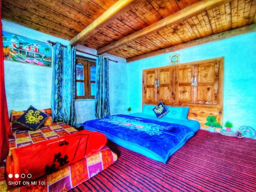 a bedroom with a blue bed and a red bed sidx sidx at Pahadi Basera in Banjār