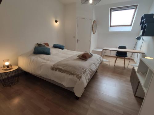 a bedroom with a bed and a table and a desk at Résidence Beaudelot in Saint-Saulve