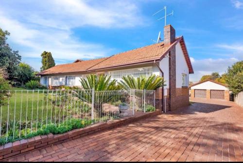 a house with a fence in front of it at Revive Haven Guesthouse in Roodepoort