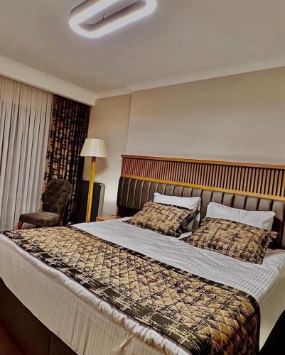 a hotel room with a large bed and a chair at Özkaya hotel in Sivas