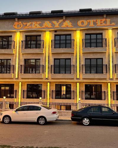 two cars parked in front of a building at Özkaya hotel in Sivas