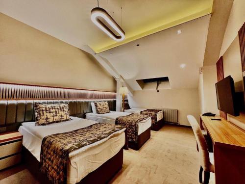 a hotel room with two beds and a desk at Özkaya hotel in Sivas