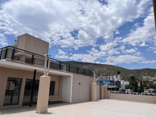 un edificio con un banco encima en Depto Tatiana zona céntrica Carlos Paz en Villa Carlos Paz