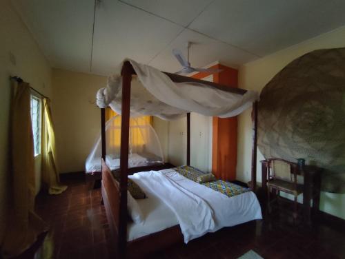 a bedroom with a four poster bed with a canopy at Villa Liwonde - Cottage in Liwonde
