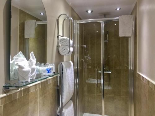 uma casa de banho com um chuveiro e uma cabina de duche em vidro. em The Corner House Bed & Breakfast em Whitehaven