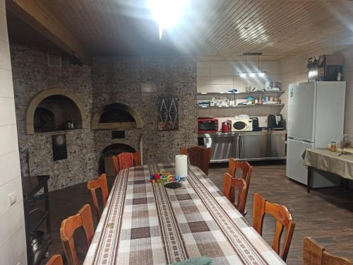 a kitchen with a table with chairs and a refrigerator at У Павла in Yablunytsya