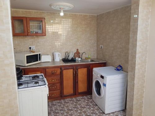 a kitchen with a washing machine and a microwave at The bb's in Brusubi