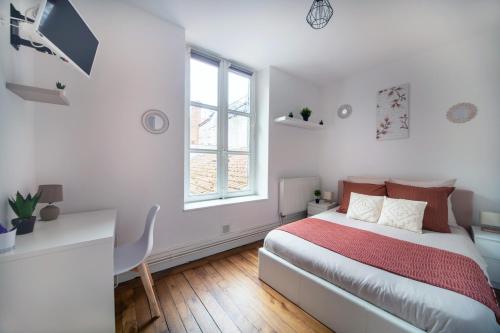een witte slaapkamer met een bed en een raam bij Appartement L'Hyper-Centre Bressan in Bourg-en-Bresse
