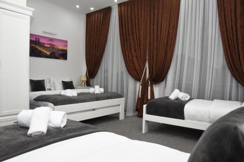 Cette chambre comprend 2 lits et des rideaux. dans l'établissement Hotel PALACE, à Velika Kladuša