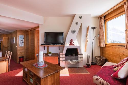 a living room with a fireplace and a tv at Spacious Stylish apartment for 8 by Avoriaz Chalets in Avoriaz