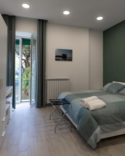um quarto com uma cama e uma grande janela em Dimora Cavour em Nápoles