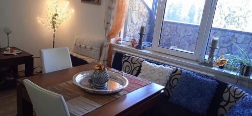 a dining room with a wooden table with chairs and windows at Спа,ски апартамент Дайли, Стрийм Ризорт Пампорово in Pamporovo