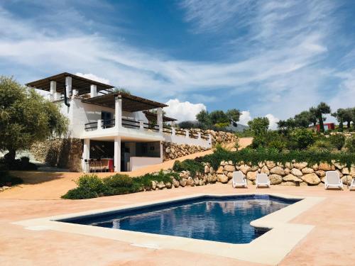 Villa con piscina frente a una casa en Casita Zayas - Guesthouse en Periana